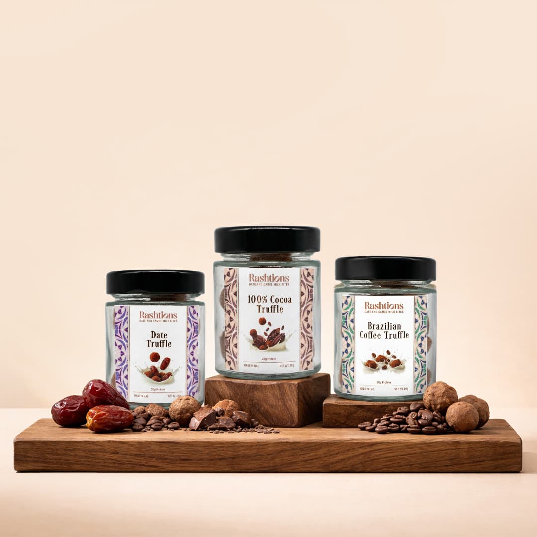 Rashtions Date Truffle, 100% Cocoa Truffle, and Brazilian Coffee Truffle jars on a wooden board with dates, cocoa, and coffee beans